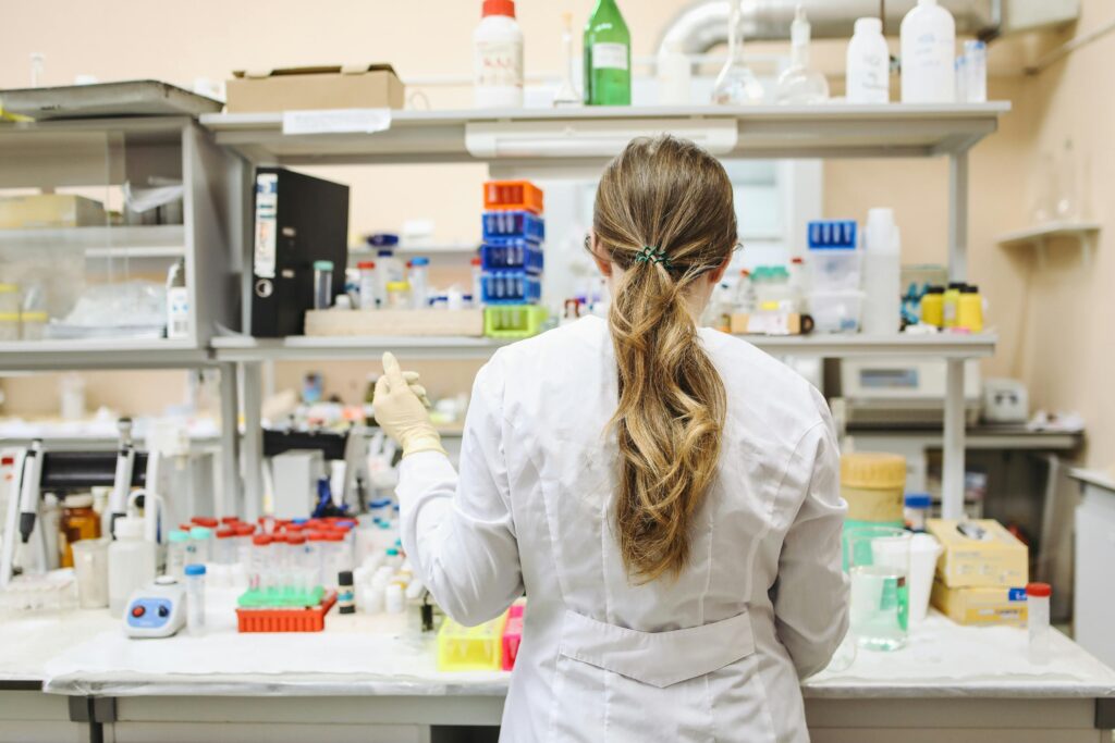 Woman in white long sleeved laboratory gown standing
